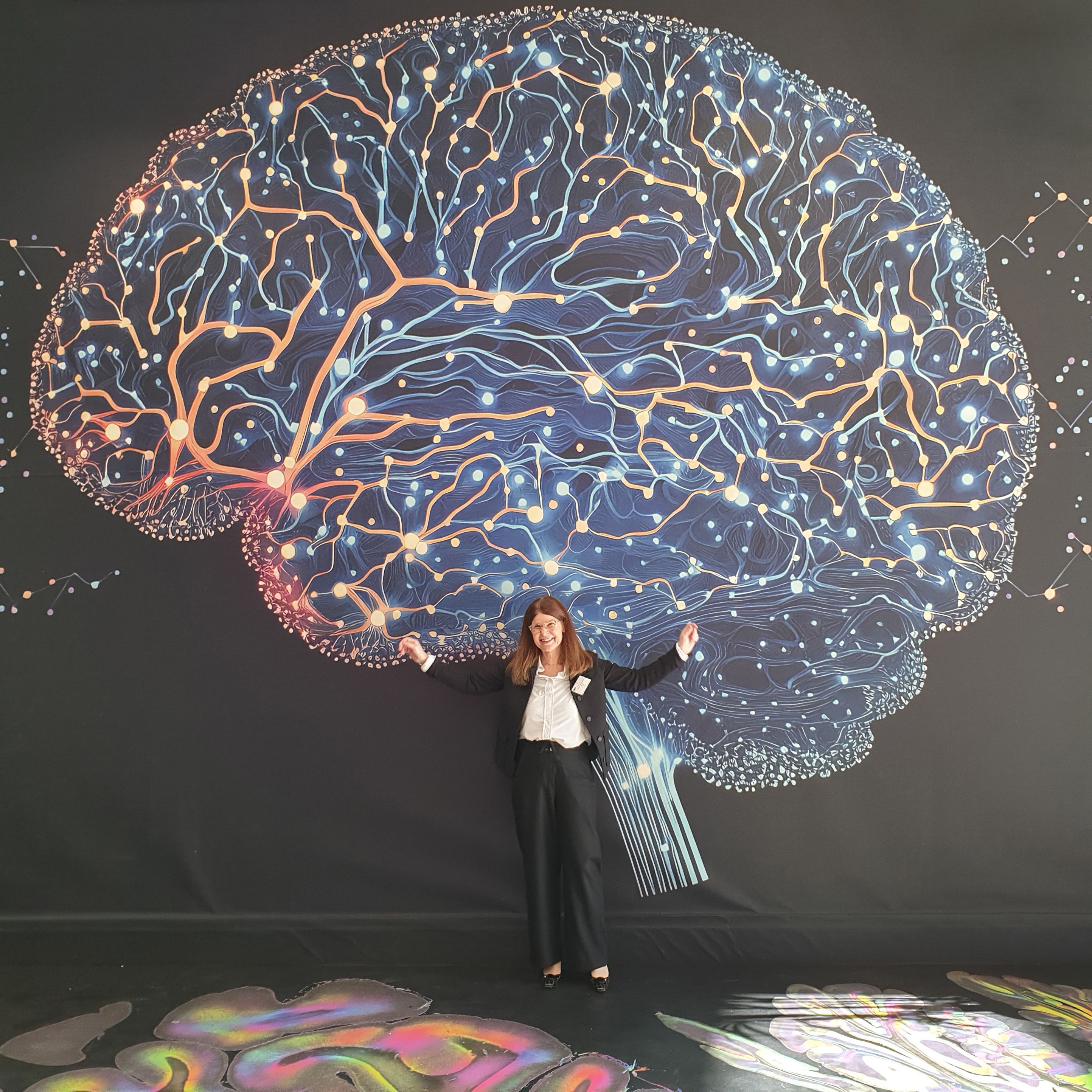 EBRAINS Joint-CEO Katrin Amunts in front of one of the images from the exhibition.