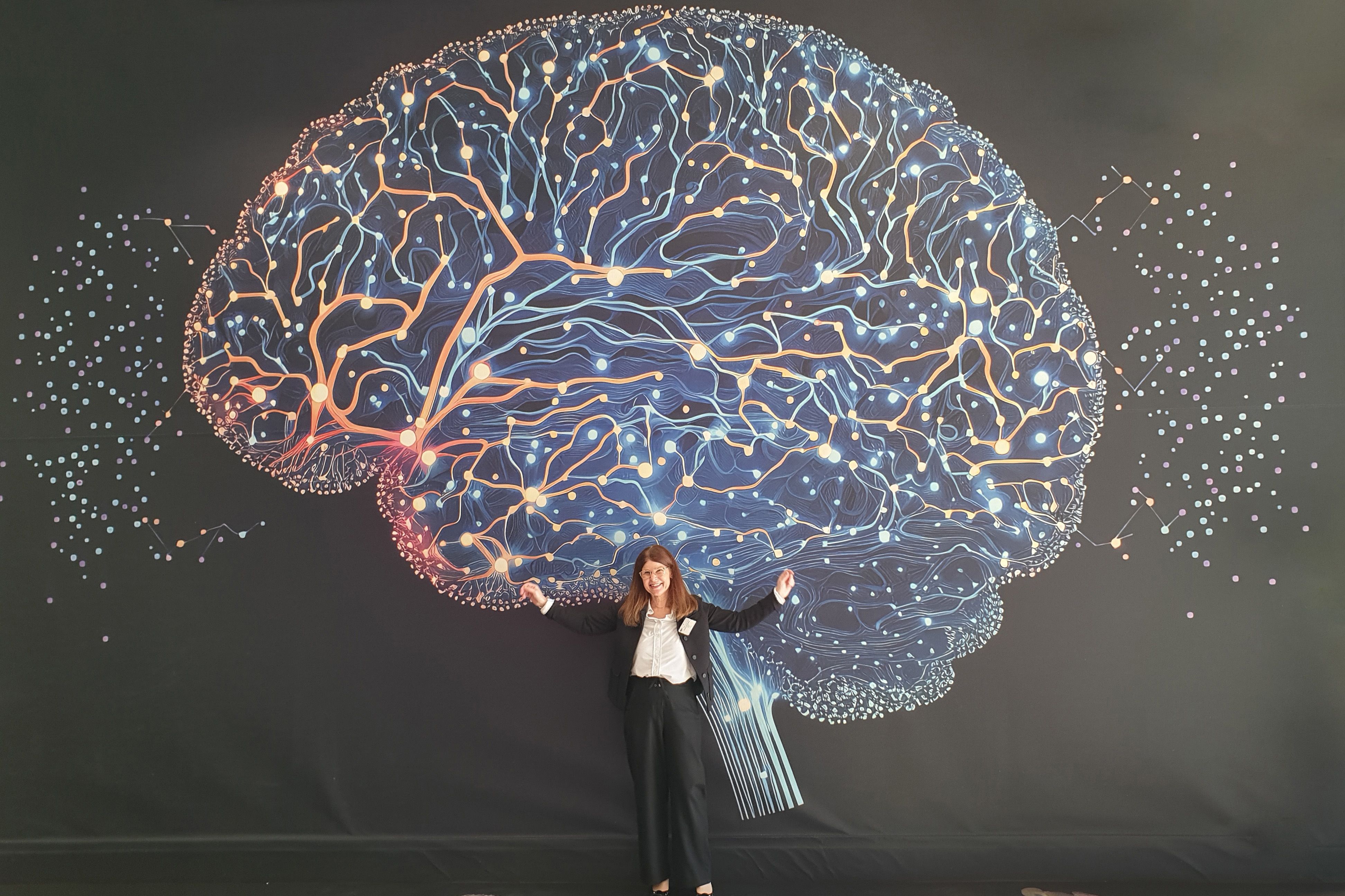 EBRAINS Joint-CEO Katrin Amunts in front of one of the images from the exhibition.